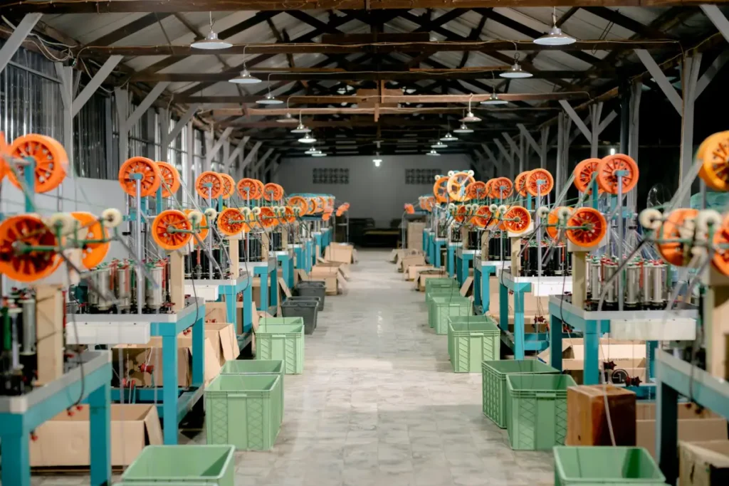 Suasana lantai produksi pabrik dengan mesin dan peralatan industri untuk menggambarkan proses menghitung biaya produksi